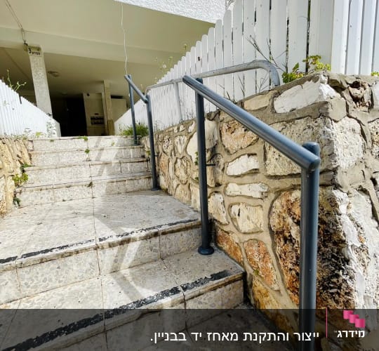 מעקה מתכת אפור על מדרגות אבן חיצוניות